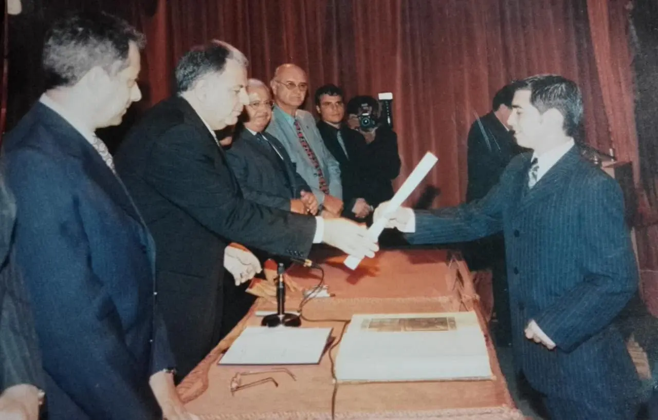 Gustavo receiving his degree during a formal graduation ceremony.