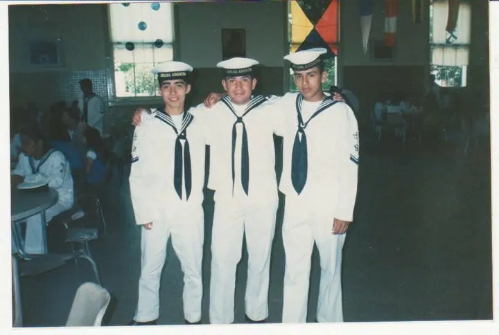 Gustavo with fellow sailors in formal white Navy uniforms.