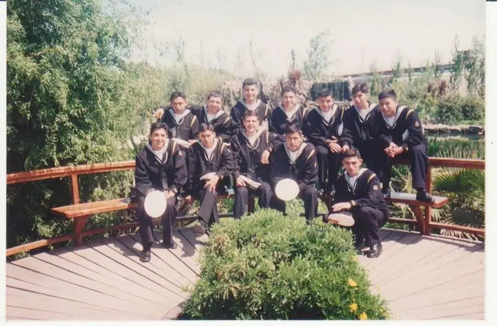 Gustavo with fellow Argentinian Navy sailors in dark uniforms outdoors.